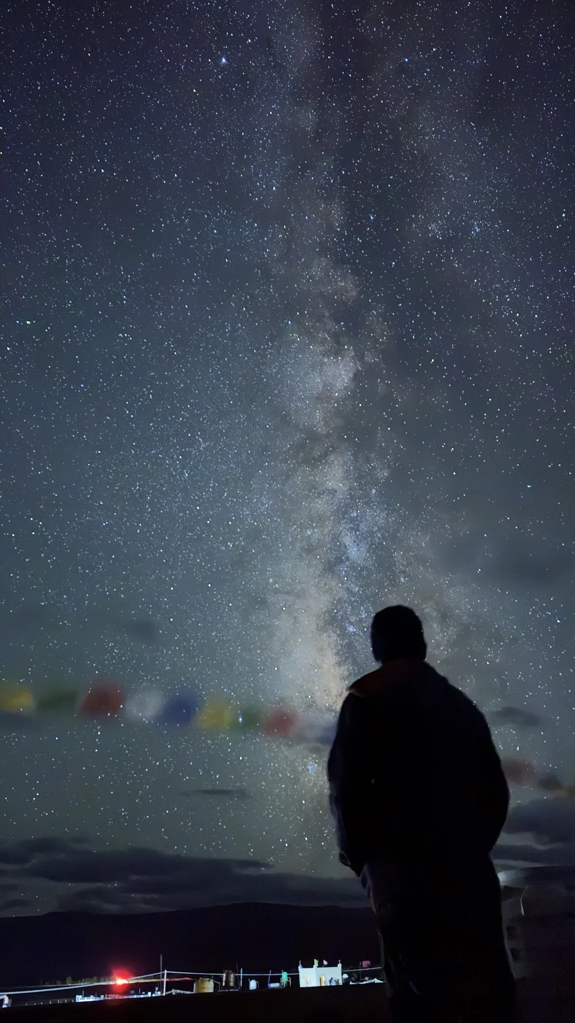 Looking up at the Milky Way from Hanle, prayer flags and village lights below